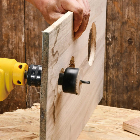 Using Beast Hole Saw Kit With 27 Piece Set Including 13 Blades From Three Quarter Inch To Five Inch Mandrels on wood board