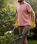 Person wearing Tough Cowhide Leather Work Gloves With Flex Grip For Wood Cutting, Construction, Driving, And Gardening For Men And Women, pushing wheelbarrow.