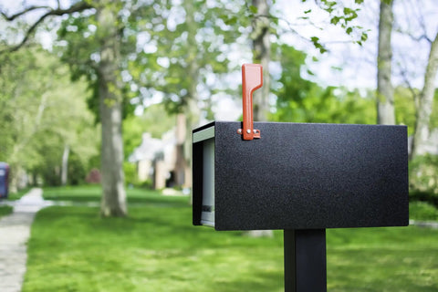 Red Galvanized Steel Mailbox Flag Replacement Kit For Outdoor Use Heavy Duty And Weather Resistant Finish Built To Last Durable Metal Flag For Residential Mailboxes on a black mailbox with trees in the background