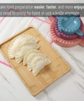 Three Size Dough Press Set In Vibrant Colors For Dumplings Empanadas Pastries Turnovers Hand Pies And Meat Pies with easy-grip handles next to crimped-edged uncooked dumplings on a wooden board
