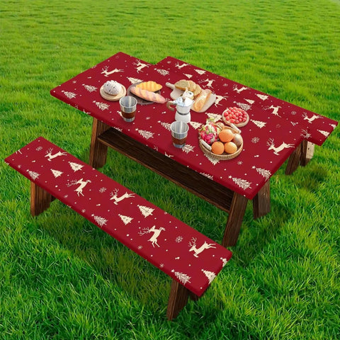 Christmas Reindeer Fitted Picnic Table and Bench Cover Set with reindeer pattern on a table in a grassy backyard.