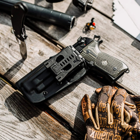 Tough As Nails USA Made Belt Clip Attachment For Concealed Carry Holsters with knife and gloves on rustic wood.