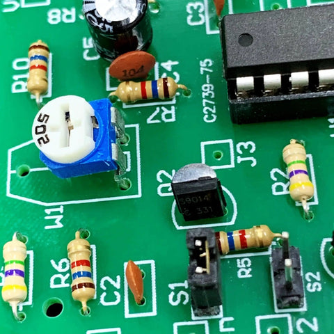 Close-up of a circuit board with Resistor Assortment Kit With 1400 Carbon Film Resistors, 140 Values, for DIY electronics.