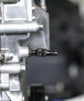 ARES 10100 thread chaser installed in automotive engine block; black carbon steel tool