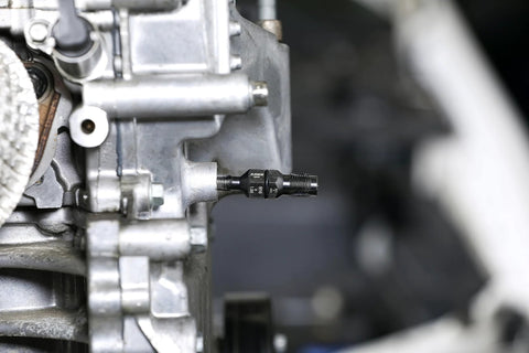 ARES 10100 thread chaser installed in automotive engine block; black carbon steel tool