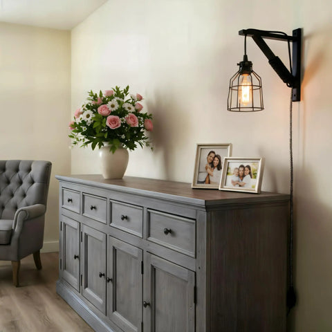 Interior view with black wooden triangle wall mount bracket for sconce lighting above a grey cabinet with decor.