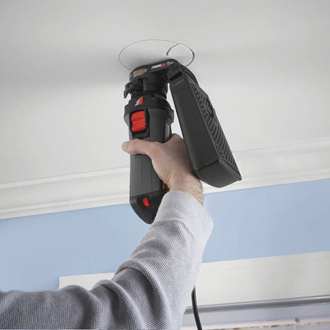 Person using Badass Job Site Ready 6 Amp Roto Spiral Saw Kit with dust attachment to cut drywall on ceiling.
