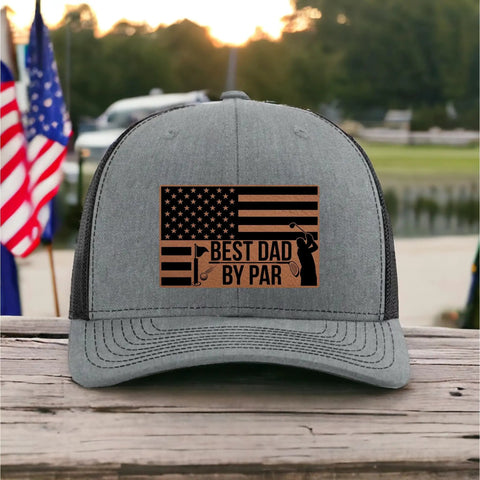 Gray funny golf hat with 'Best Dad By Par' text and leatherette patch, perfect gift for Fathers Day. Background shows American flag.