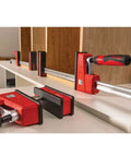 Heavy Duty 40 Inch Parallel Clamp Delivering 1700 Lbs Of Tight Grip For Woodworking Cabinetry viewed on a workbench with wooden panels.