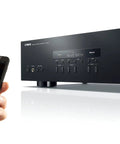 Front view of R S202BL Stereo Receiver With Bluetooth For Streaming Your Tunes Dual Speaker Outputs Auto Power Standby Two System Speaker Selector FM AM Presets Headphone Terminal High Fidelity Home Audio System with a smartphone streaming.