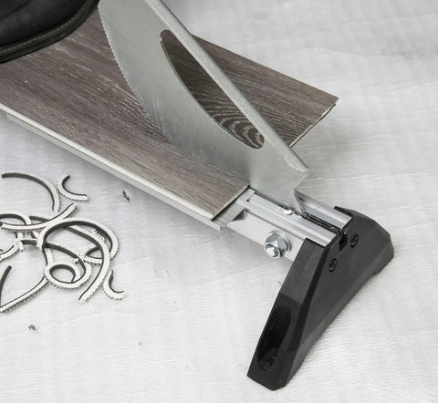 Close-up of fully assembled laminate and vinyl floor cutter for small jobs, cutting a laminate plank, showing clean cuts and precision.
