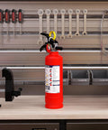 No Fuss ABC Home Fire Extinguisher 2.5 Lb Two Pack Top Shelf Rated Class A B C For Kitchen Garage on workshop table.