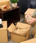 Person using Eco Friendly Kraft Bubble Paper Wrap Sheets 12x12 Inches For Packing Moving And Shipping Recyclable Cushioning to wrap glassware