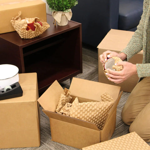 Person using Eco Friendly Kraft Bubble Paper Wrap Sheets 12x12 Inches For Packing Moving And Shipping Recyclable Cushioning to wrap glassware