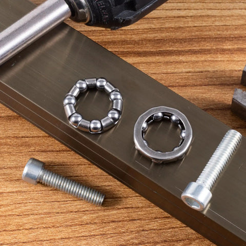 Four Pack 0.2 Inch Ball Bicycle Bearing Set For Crank Bottom Bracket Axle Replacement shown with screws on wood surface