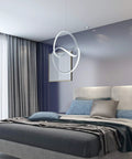 Lit Modern LED Pendant Light With Irregular Ring Design, 6000K Cool White hanging over modern bedroom, silver finish