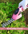 Pink 2-In-1 Electric Handheld Grass Shear And Hedge Trimmer Cordless Battery Powered No Fuss Garden Tool on green bushes