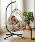 Relaxing woman reading in Hanging Egg Chair With Stand Foldable Hammock Swing Chair Built For All Weather Use With Core Spun Polyester Rope