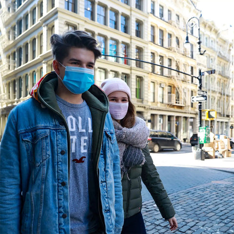 Couple wearing 4 Layer Individually Wrapped Disposable Face Masks 50 Pcs Rainbow Color With 5mm Wide Earloops on city street