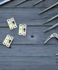 24 Pairs Metal Picture Clips And Wall Mount Brackets Hanger Kit For Picture Hanging on wooden surface with tools