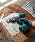 Aolidsive Cordless Metal Shear Delivering 400Nm Torque For Bl1830 Battery cutting metal sheet on a wooden table with leather and tools.