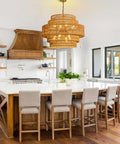 Epic Large Gold Boho Rattan Chandelier With 8 Lights hanging above a kitchen island, handwoven pendant light fixture