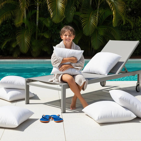 Child sitting on lounge chair with Outdoor Pillow Inserts 18 By 18 Inches Pack Of 2 White No Fuss Water Resistant Throw Pillows by the pool.