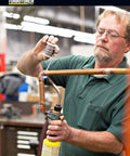 Person using Self Lighting Hand Torch TX504 With Extreme Swirl Technology for brazing copper pipes in workshop setting.