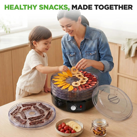 Nutrichef Electric Countertop Food Dehydrator with fruit and beef jerky on 5 stackable trays, mom and child preparing snacks.