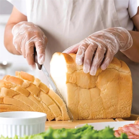 Person wearing Industrial Grade Clear Vinyl Gloves Disposable Powder Free Latex Free Non Sterile Food Safe slicing bread