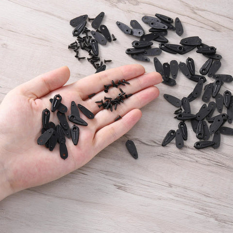 Close-up of black metal picture frame turn-button fasteners and screws in hand (100-piece set)