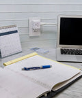 Three Outlet Wall Tap Power Splitter With Grounded 3 Prong Design Space Saving Cube Adapter in use on a desk