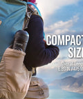 Hiker carrying Minipresso GR Portable Espresso Machine in backpack pocket with scenic mountain view, compact and travel-friendly.