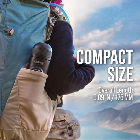 Hiker carrying Minipresso GR Portable Espresso Machine in backpack pocket with scenic mountain view, compact and travel-friendly.