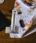Heavy Duty Metal Sewing Bed Cloth Clamps For Hemming And Fabric Quilting Workholding Tools on floral fabric with thread.