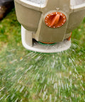 Close-up of No Crank One Touch Battery Powered Spreader for Fertilizer Seed and Ice Handheld, distributing material on grass.