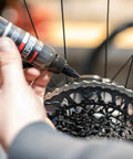 Applying Synergetic Bike Chain Lube Wet Lube 2oz Bottle With Premium Synthetic Oil And ZDDP WS2 Blend to bicycle chain for rust protection
