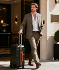Man with expandable hardside luggage set exiting hotel
