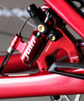 Juin F1 Hybrid hydraulic disc brake caliper, red, mounted on bicycle fork