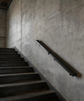 Heavy Duty Wall Mounted Stair Handrail Built From Premium Stainless Steel Providing A Rock Solid Grip And A Slick Black Finish For Dependable Daily Use And Home Safety on a concrete wall.