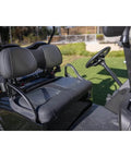 Golf cart with black leather seats parked on grass