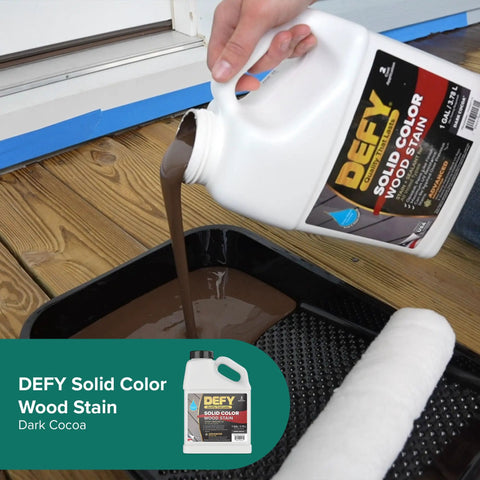 Solid Color Wood Stain For Decks And Fences UV Resistant Opaque Finish That Hides Imperfections Long Lasting Exterior Paint With Zinc Nano UV Protection 1 Gallon being poured into a paint tray.
