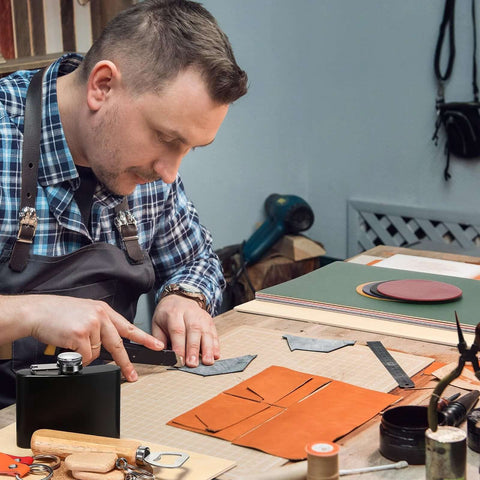 Dunzoom laser material kit: craftsman cuts orange leather shapes on a cutting mat.