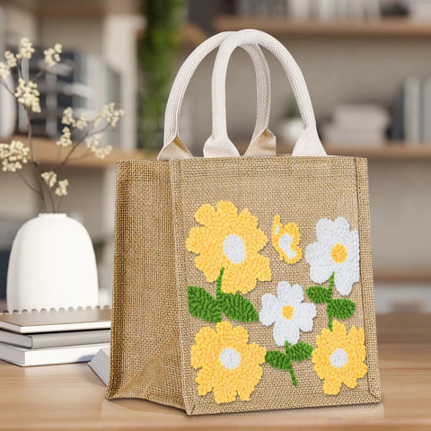 Beginner Punch Needle Kit With Tote Bag showcasing floral embroidered design on burlap material, displayed on a table.