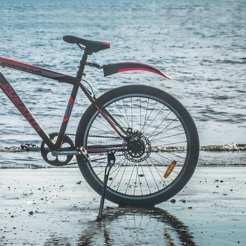 Adjustable 18mm Hole Spacing Bike Kickstand For 24, 26, And 27.5 Inch Mountain Bikes in use on beach trail