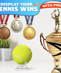Tennis ball on Clear Baseball Holder Stand 1.96 Inch Acrylic Display Stand For Baseballs Softballs Golf Balls Tennis Balls And Small Collectible Balls Perfect Desk Shelf Decor, alongside trophies and medals displaying tennis achievements.