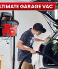 Man using 5 Gallon Wall Mount Wet Dry Vacuum With Remote Control Handle, 5 Peak HP Power for cleaning car interior in garage.