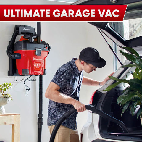 Man using 5 Gallon Wall Mount Wet Dry Vacuum With Remote Control Handle, 5 Peak HP Power for cleaning car interior in garage.