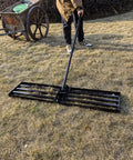 Person using Lawn Leveling Rake With 72 Inch Non Slip Handle on grass, 42 by 10 inch head visible, ergonomic 160 degree rotating head