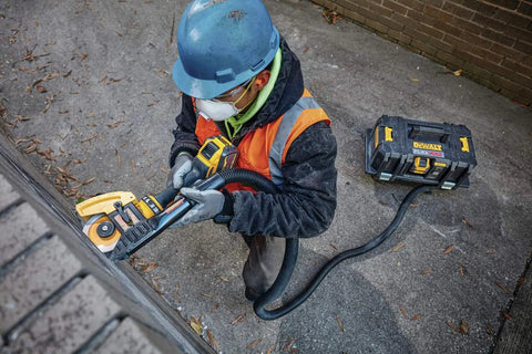Worker using 60V Max Brushless Cordless Grinder With Kickback Brake Four And A Half Inch To Six Inch Wheel on bricks